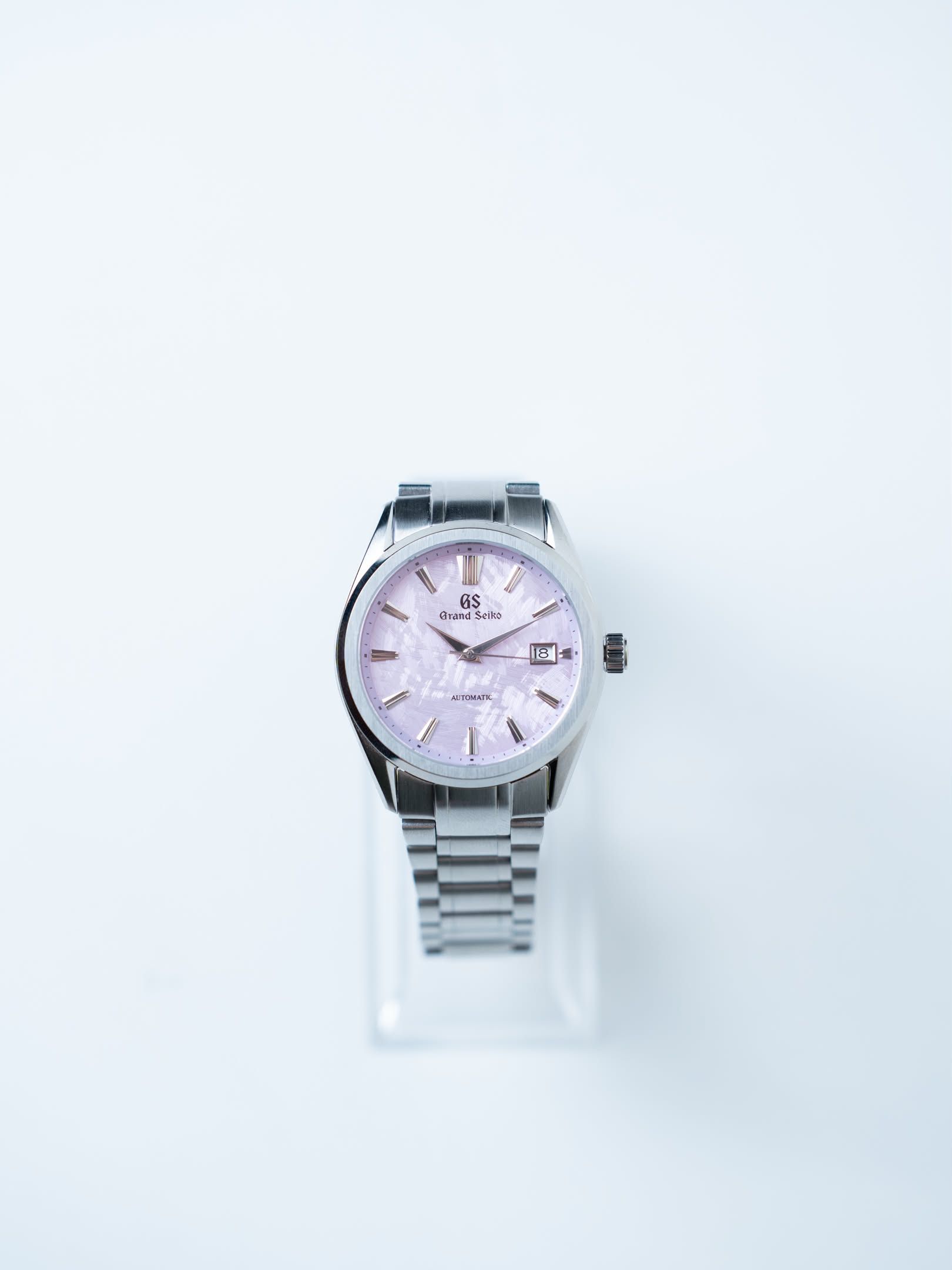 Cherry on a clear display stand, its lilac dial facing you.