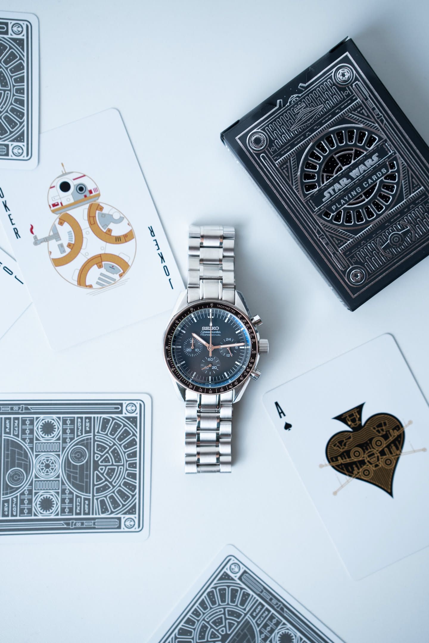 Ironwood among playing cards, its three sub-dials and rose-toned hands visible.