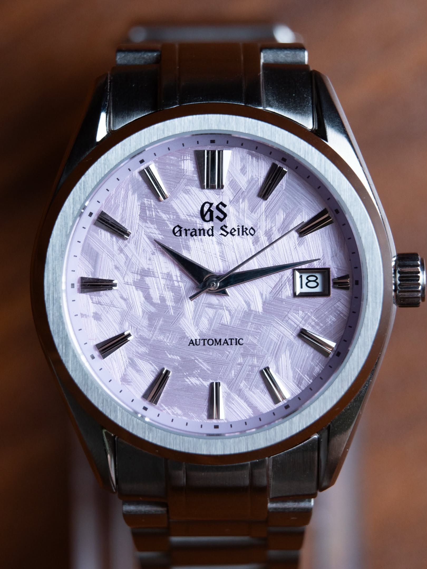Cherry up close on a wooden table, the lilac dial catching the light.