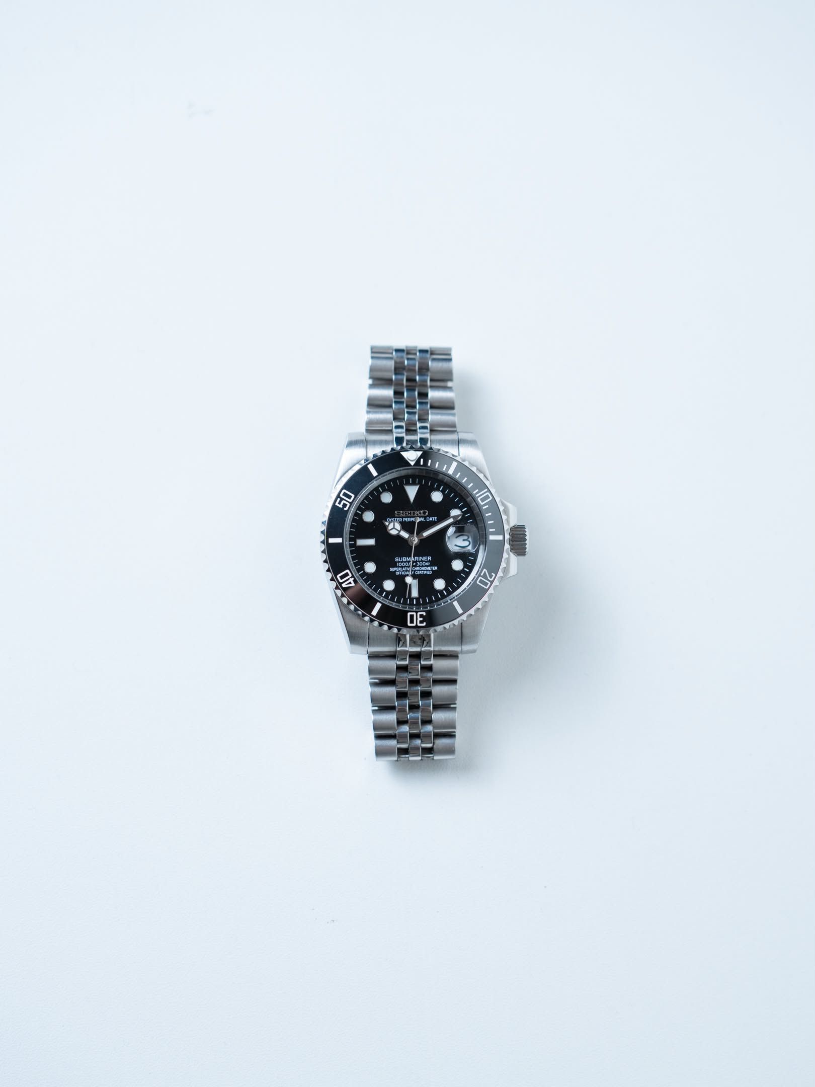 Ebony laid straight, black dial and bezel above a jubilee bracelet.